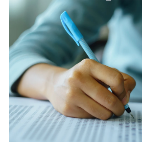 a hand filling in a test with a pencil